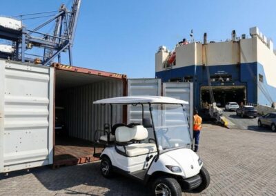 A golf cart next to a shipping container at a port for RoRo export.